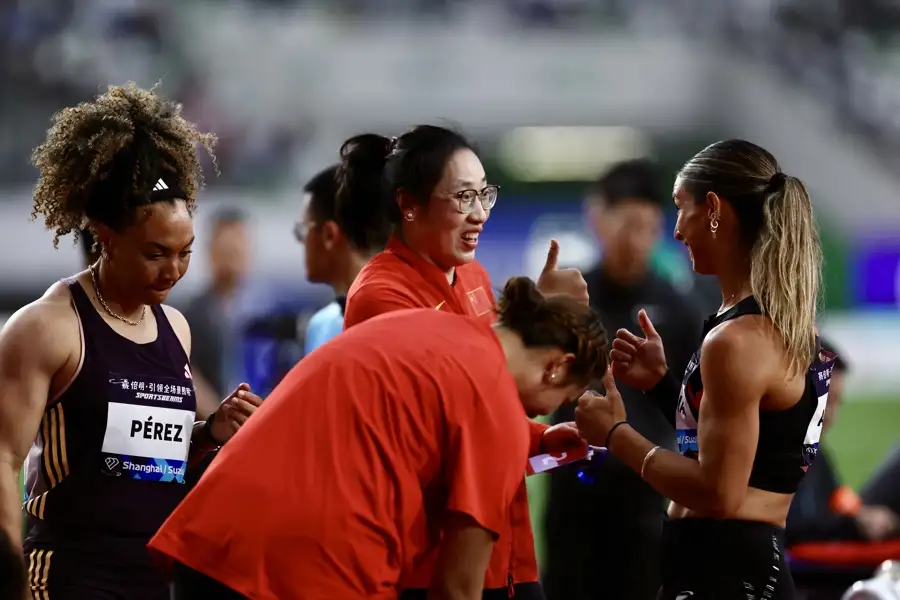 中國隊選手馮彬（左二）和美國隊選手瓦拉麗·奧爾曼（右一）在女子鐵餅比賽後交流。.jpeg