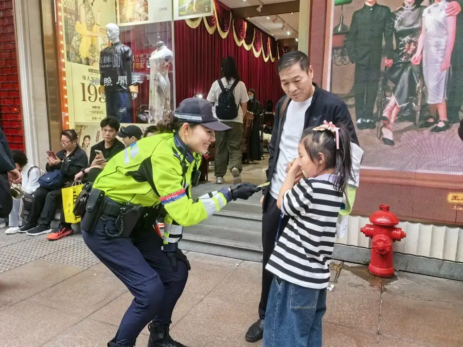 徐懿向哭鬧的小朋友遞上棒棒糖。黃浦警察供圖.jpeg